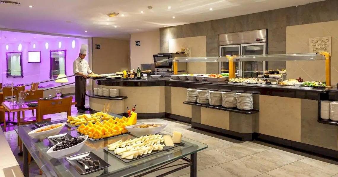 Buffet im Sol Lanzarote All Inclusive Hotel mit verschiedenen Speisen und einem Kellner, der serviert.
