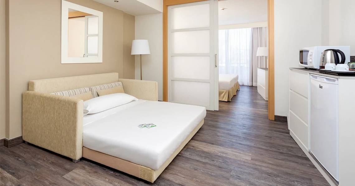 Hotelzimmer des Sol Lanzarote All Inclusive mit Schlafsofa, Tischlampe und Küche