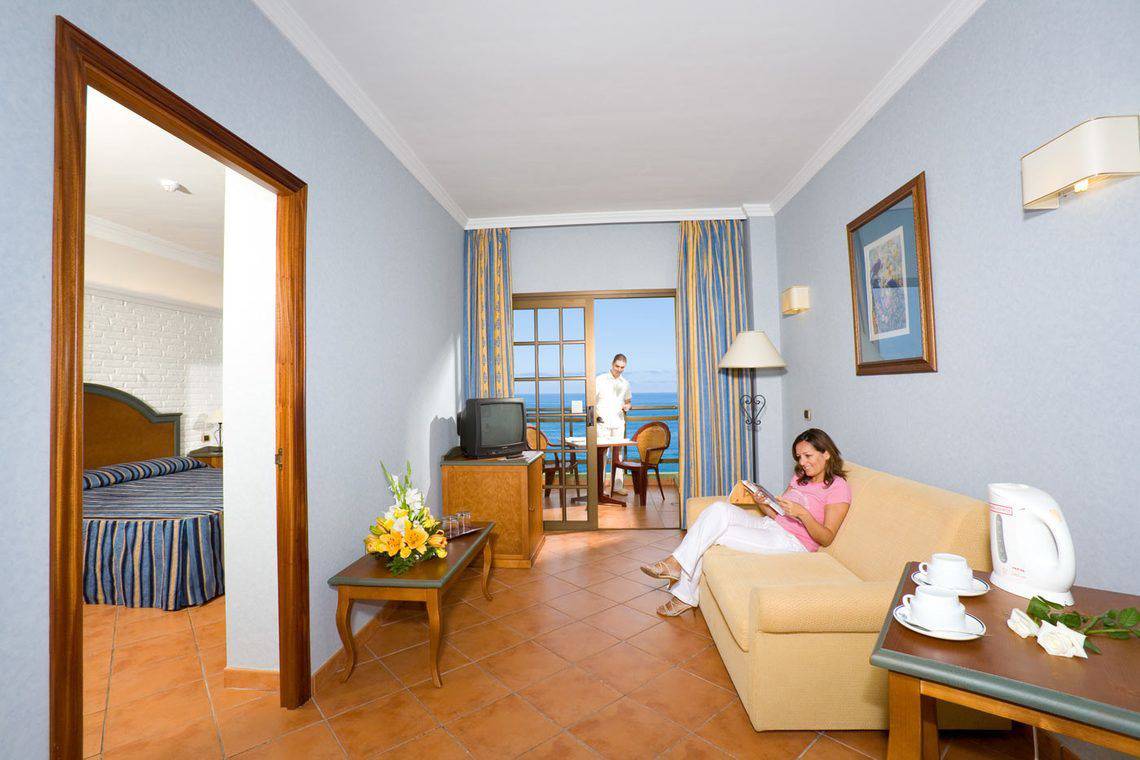 Innenansicht des AluaSoul Orotava Valley Hotels mit Frau auf Sofa und Meerblick