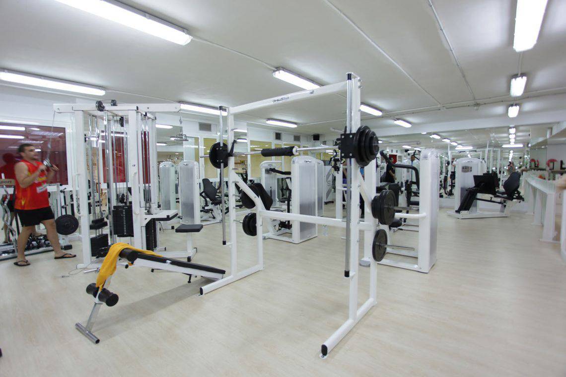 Fitnesscenter im AluaSoul Orotava Valley Hotel mit vielen Geräten und einem Mann, der Gewichte hebt.