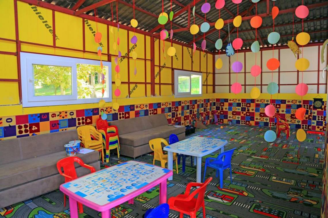 Kinderzimmer im LABRANDA Ephesus Princess Hotel mit bunten Spieltischen, Stühlen und Sofas.