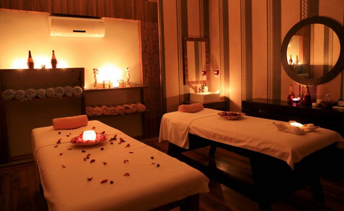 Massage-Behandlungsraum im LABRANDA Ephesus Princess Hotel mit zwei Behandlungstischen, Kerzen und Rosenblättern.
