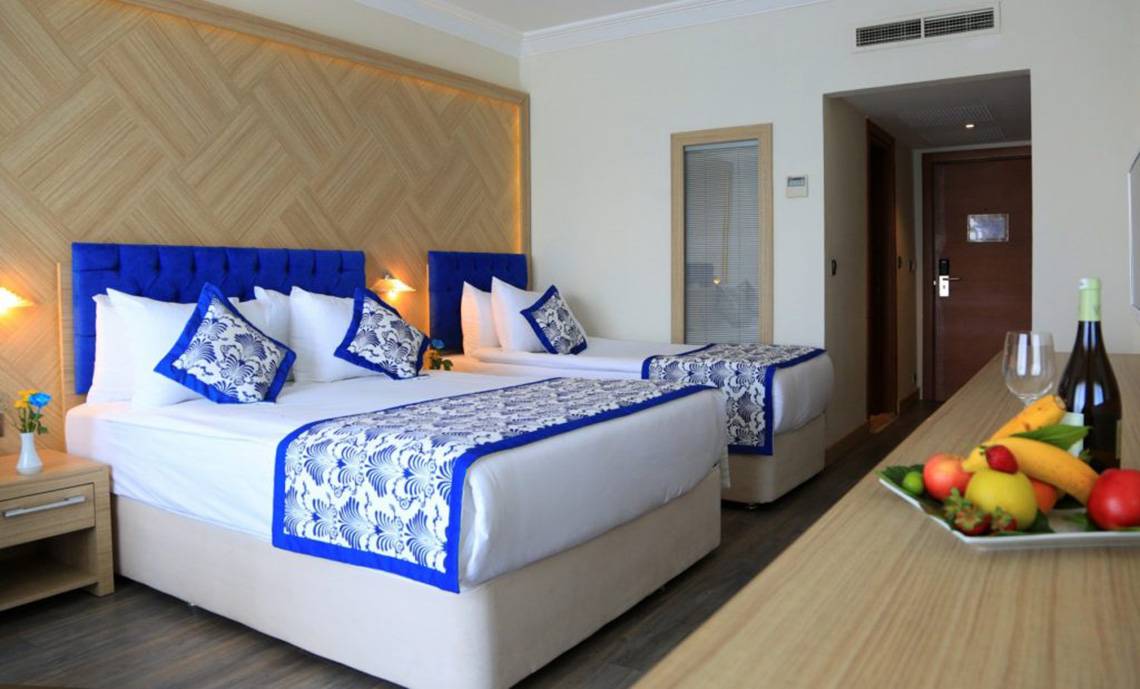 Doppelzimmer im LABRANDA Ephesus Princess Hotel mit zwei Betten, Früchten und Getränken.