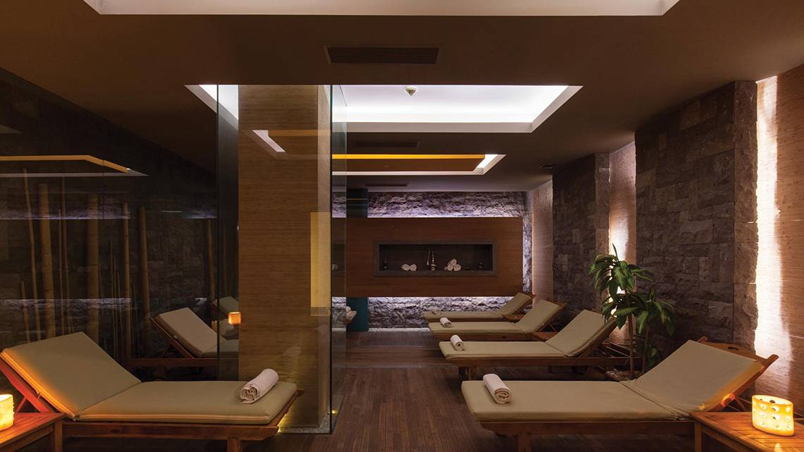 Sauna Bereich im Kempinski Hotel The Dome Belek mit Holzliegen und Steinwänden.