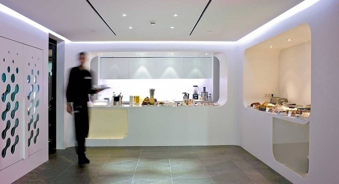 Frühstücksbereich des Barcelo Raval Hotels mit moderner Inneneinrichtung und einem Mitarbeiter, der serviert.