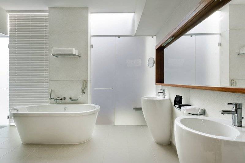 Modernes Badezimmer mit Badewanne, Waschbecken und Spiegel im Melia Zanzibar Hotel.