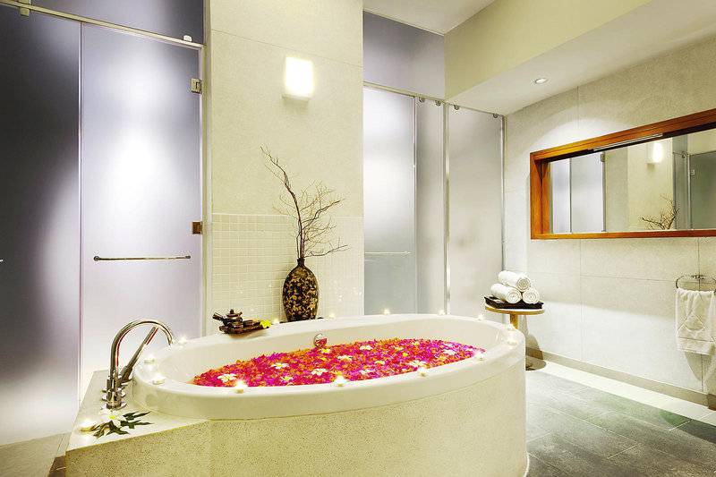 Badezimmer im Melia Zanzibar mit einer Badewanne voller Blumen und Kerzen