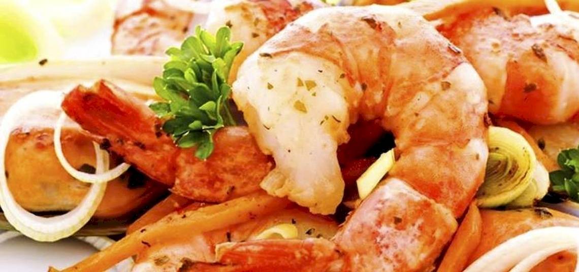 Gegrillte Garnelen mit Zwiebeln und Petersilie auf einem Teller serviert