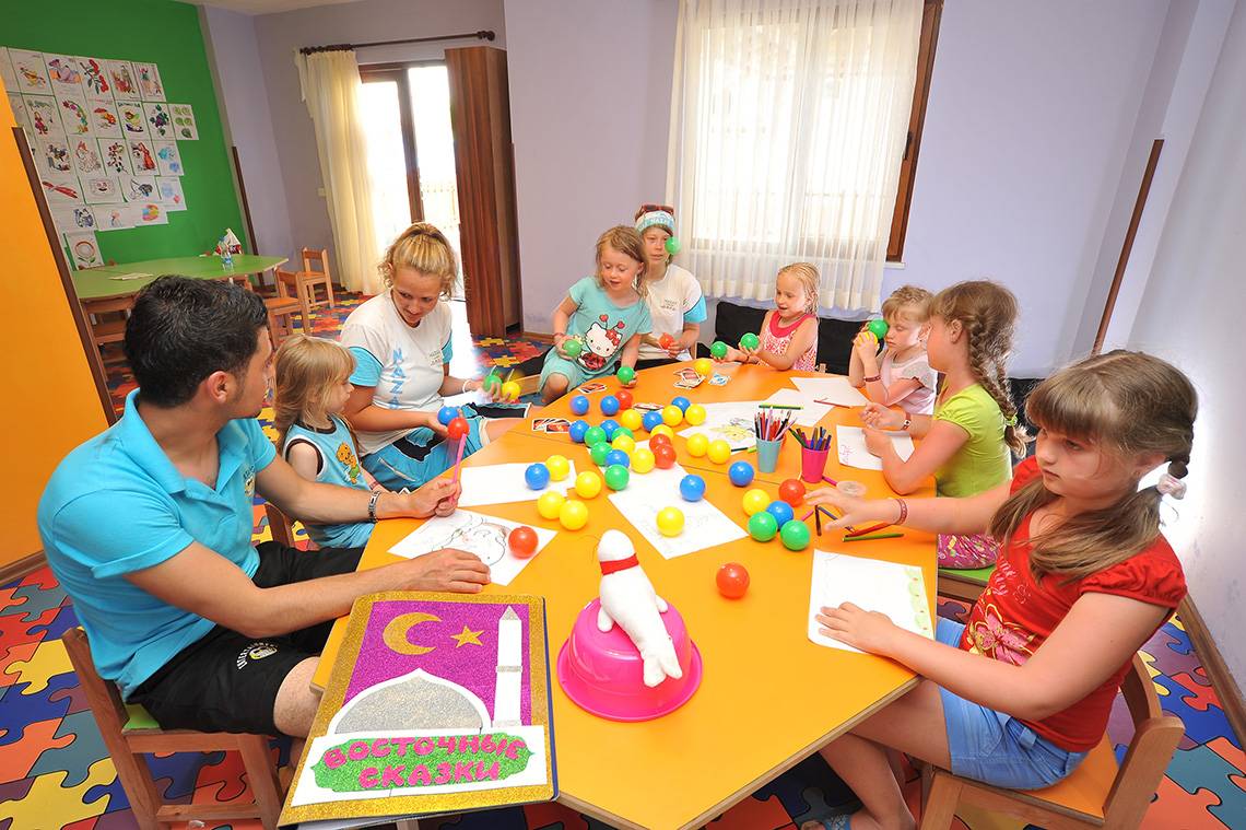 Gruppe von Kindern und Erwachsenen, die in einem farbenfrohen Raum basteln, im Eftalia Aqua Resort.