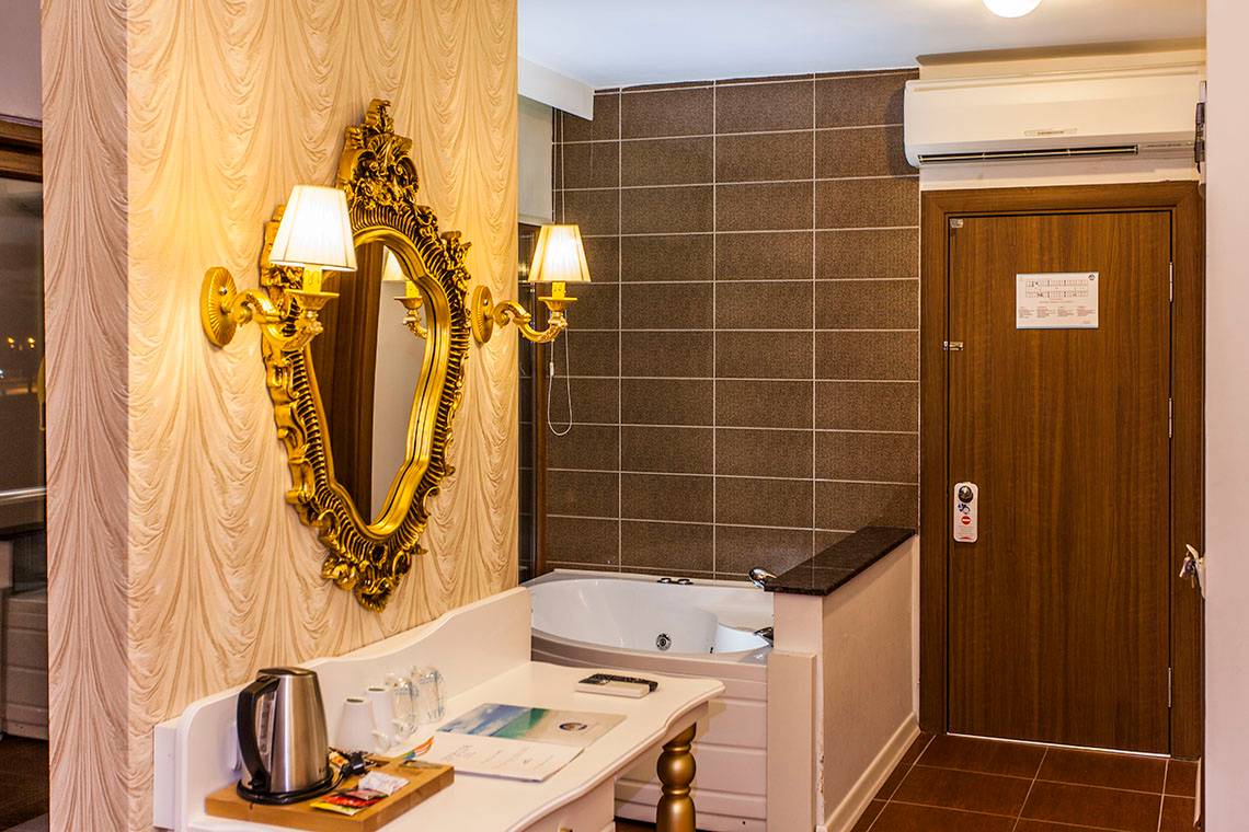 Hotelsuite Badezimmer mit Badewanne, Spiegel und Deko-Elementen im Eftalia Aqua Resort.