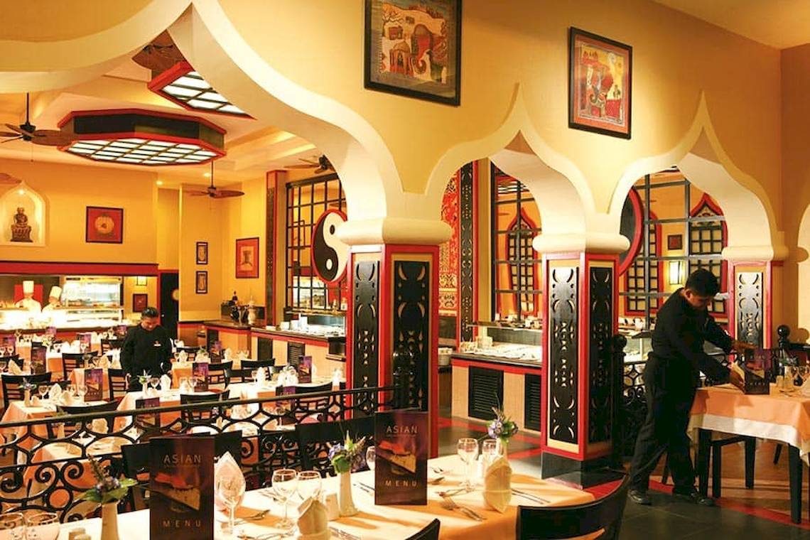 Innenansicht des Riu Caribe Hotels, Kellner bedient Tische im Restaurant