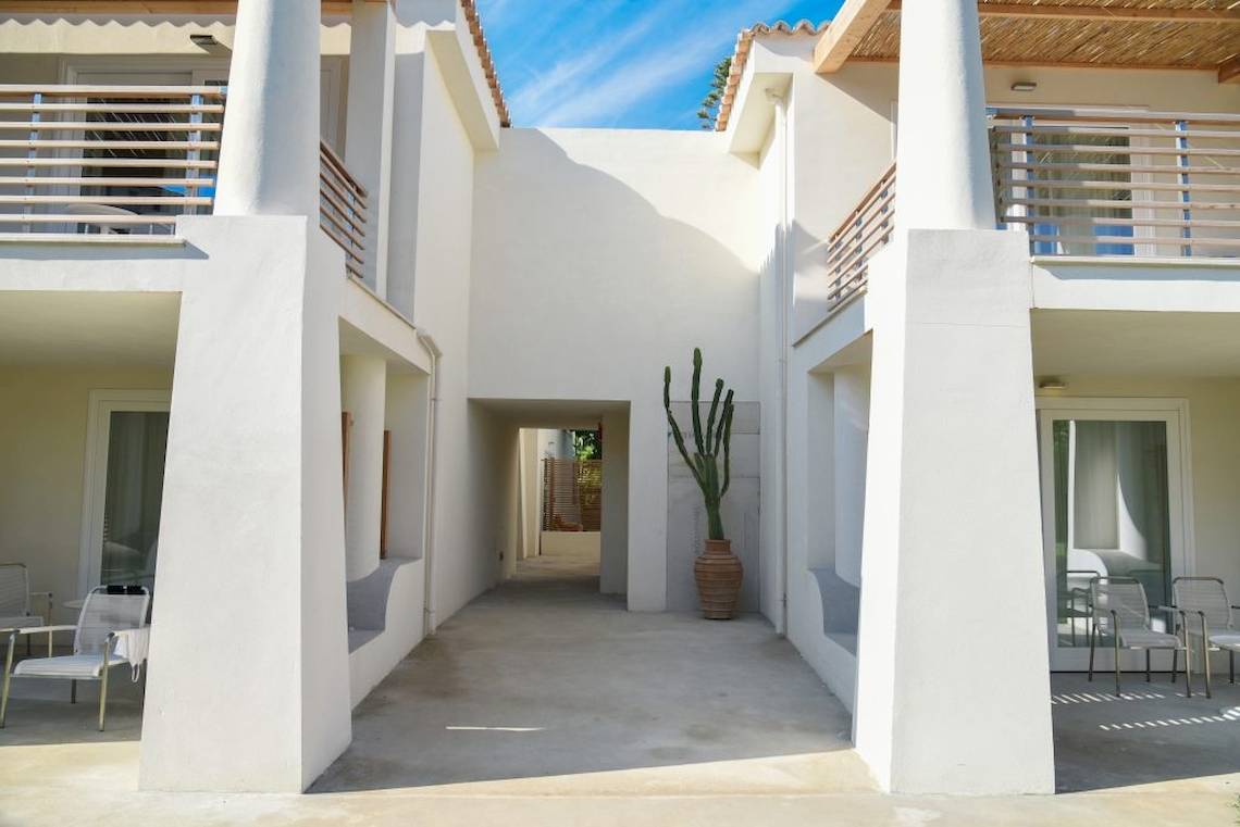 Außenbereich des Baia del Sole Hotels mit weißem Gebäude, Balkon, Eingangsbereich und Kaktus