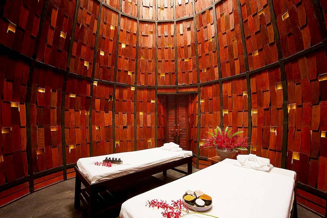 Massageraum im Tubkaak Krabi Boutique Resort mit zwei Liegen und roten Blumendekor.