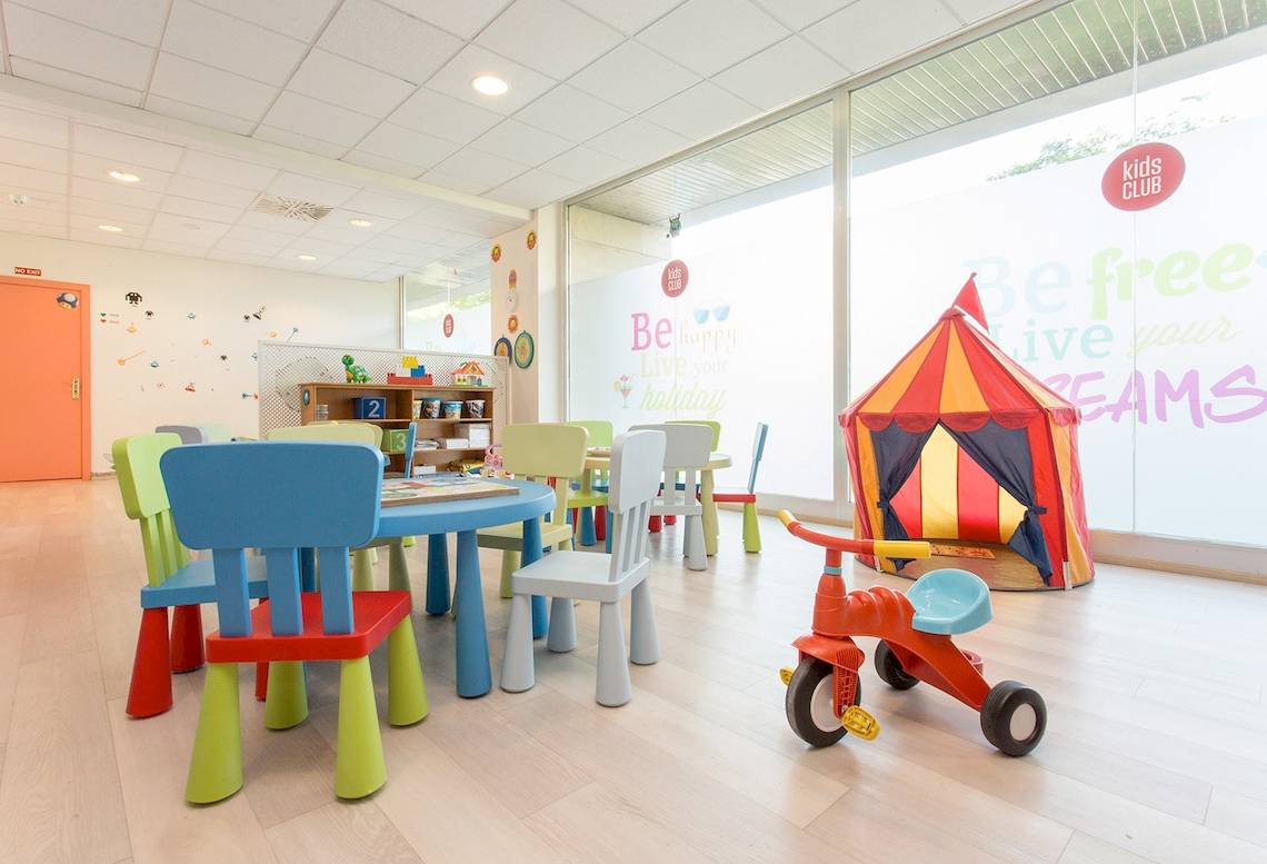Kinderzimmer im Sarena de Muro Resort Mallorca mit bunten Stühlen und Tisch, Spielzeug und einem kleinen Zelt.