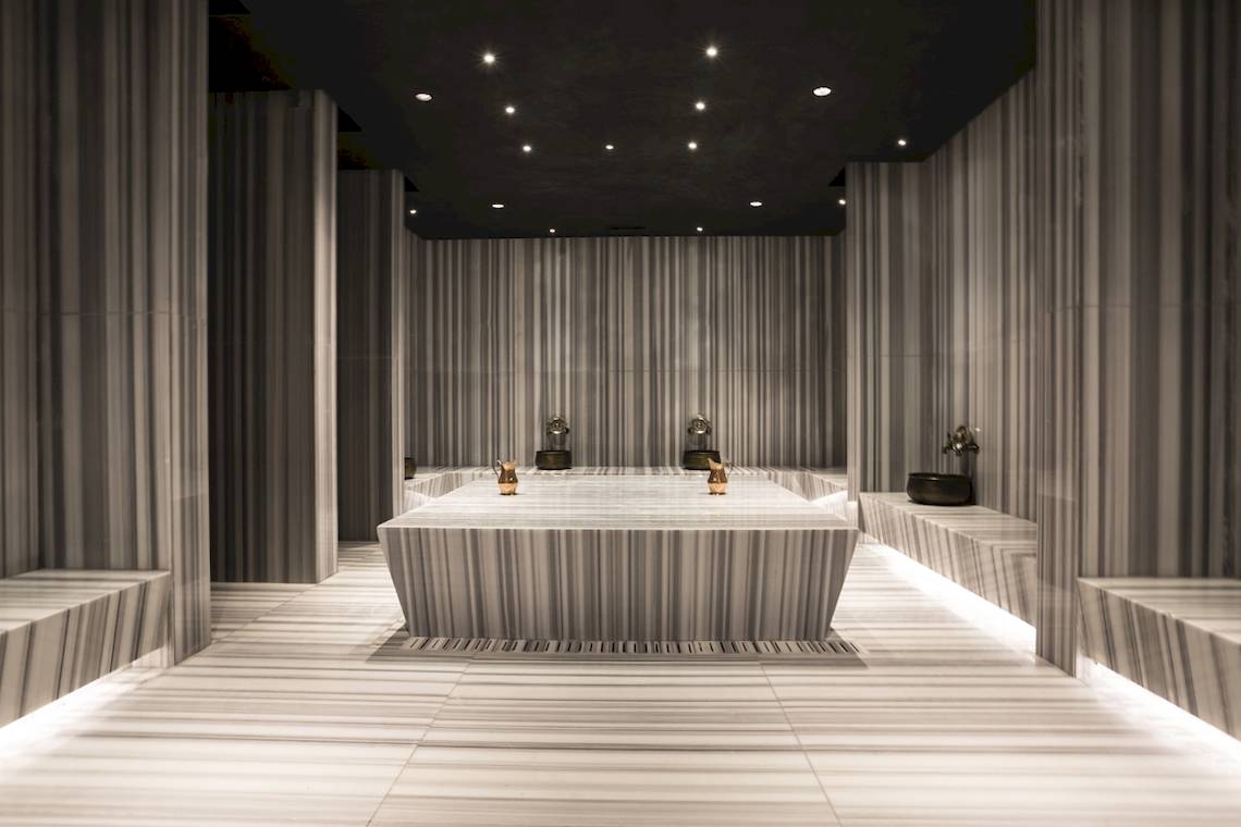 Innenansicht der Sauna im Voyage Sorgun Hotel mit Marmorwänden und zentralen Wasserbecken.