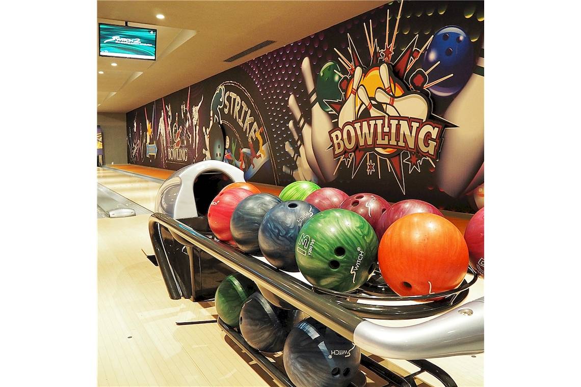 Bowlingbahn im Voyage Sorgun Hotel mit bunten Bowlingkugeln und Bowling-Wanddesign.