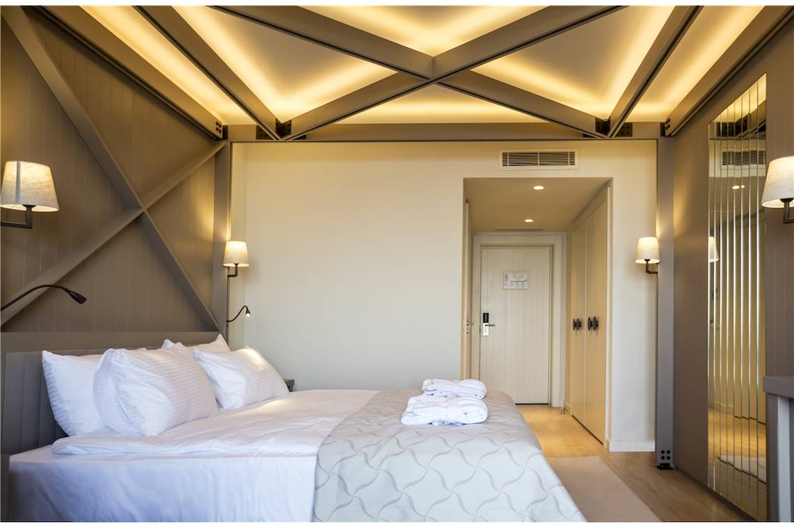 Ein modernes Schlafzimmer im Voyage Sorgun Hotel mit einem großen Bett und weißen Bettwäsche.