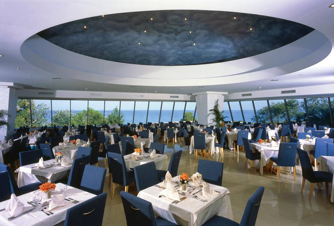 Innenansicht des Restaurants im Calypso Beach Hotel mit Blick auf das Meer.
