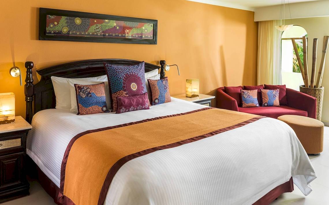 Hotelzimmer mit Bett und Sofa im El Dorado Royale a Spa Resort by Karisma