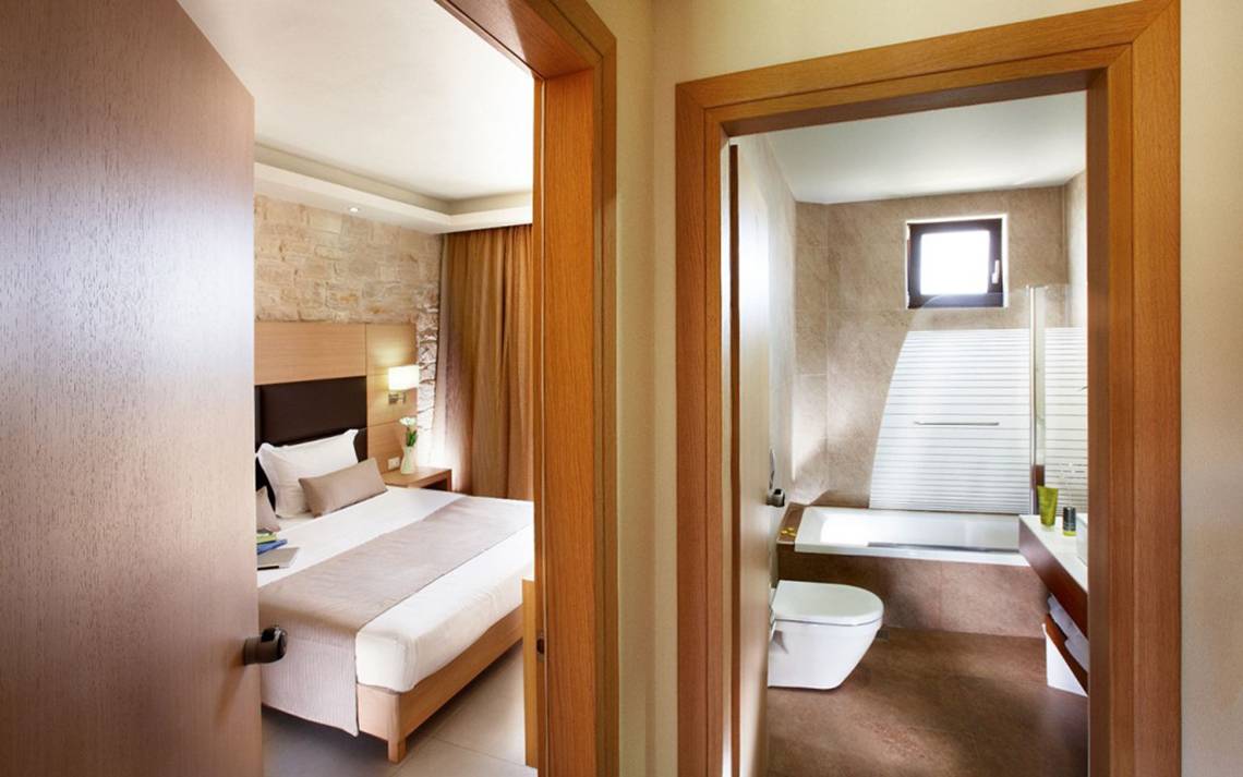 Innenansicht eines Hotelzimmers von Anna's House mit Bett, Badezimmer und Badewanne.