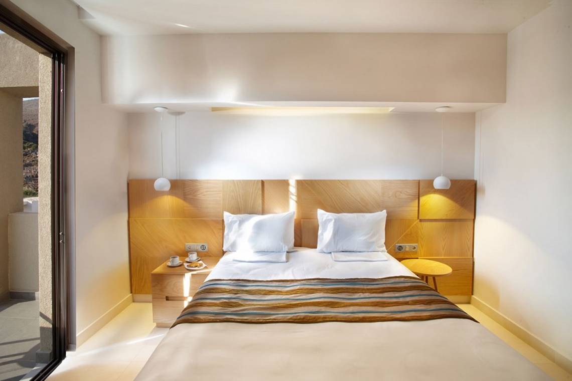 Ein modernes Zimmer von Anna's House mit einem Bett, Bettzeug und Nachttischen.