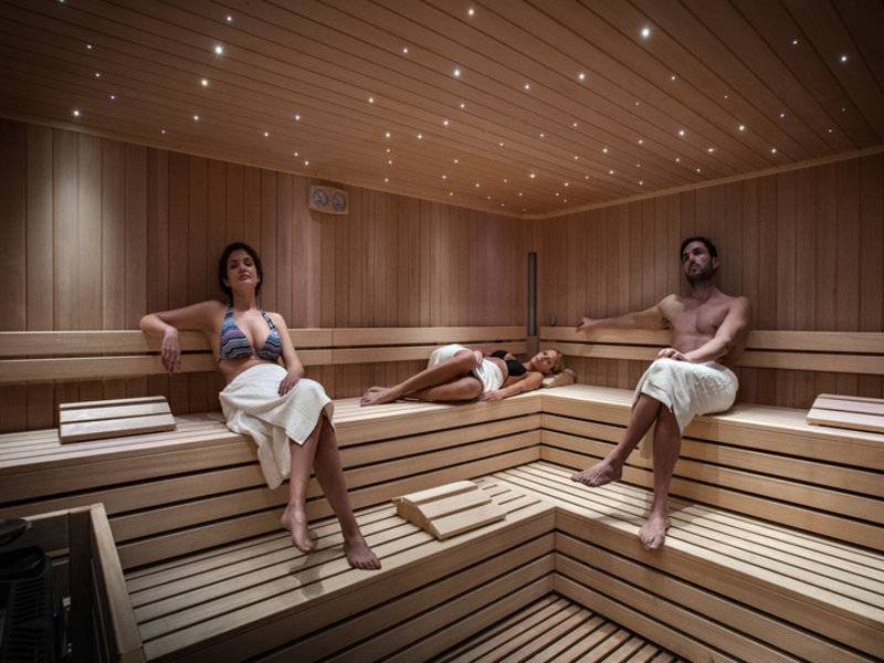Drei Personen in einer Holzsauna des Grand Hotel Resort Ma&Ma