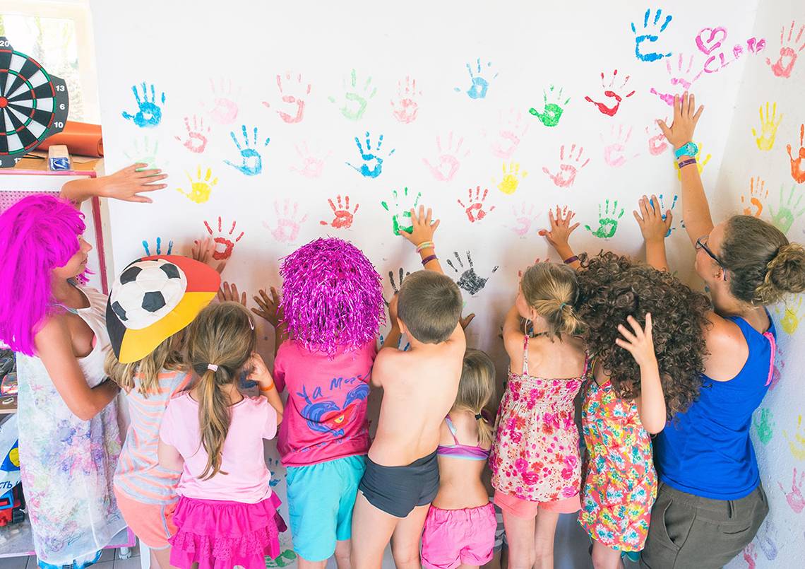 Kinder mit bunten Handabdrücken an einer Wand im Stella Village Hotel & Bungalows.