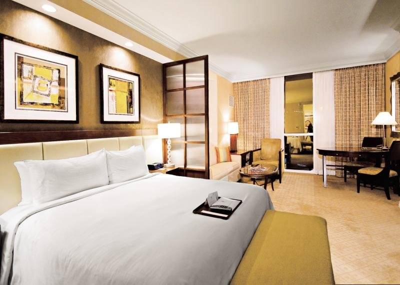 Hotelzimmer im The Signature at MGM Grand mit Bett, Schreibtisch und Fenstern.