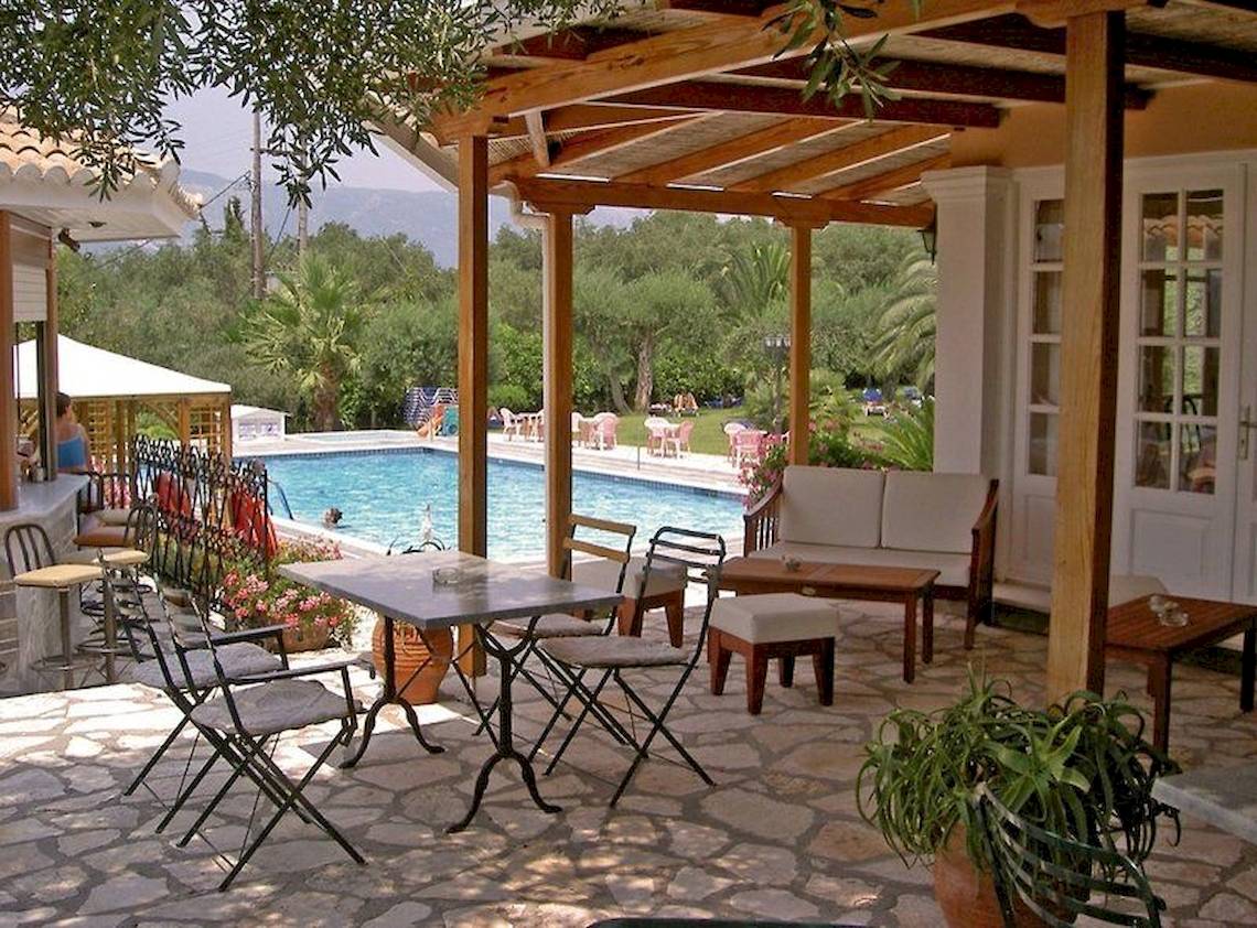 Terrasse des Nefeli Hotels mit Tisch, Stühlen und Blick auf den Pool