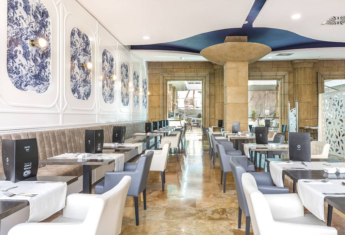 Innenansicht des Restaurants im Be Live Experience La Nina Hotel mit blauen Wandverkleidungen und runden Deckenleuchten.