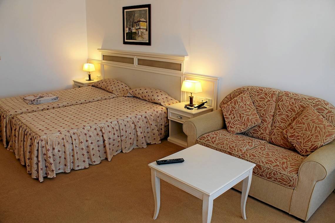 Doppelzimmer im Helena Sands Hotel mit zwei Betten und einem Sofa.