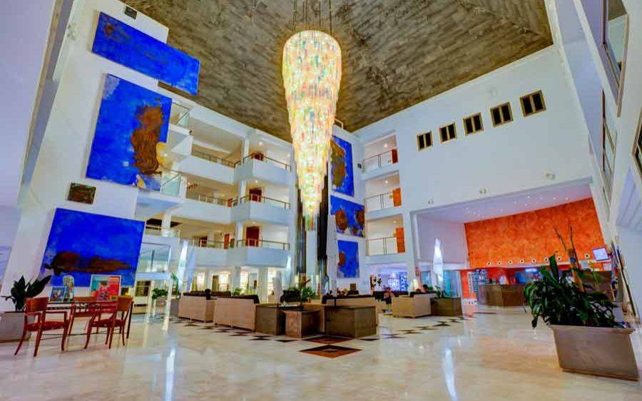 Lobby des SBH Costa Calma Beach Resort mit großen Kronleuchter und blauen Wandkunstwerken.