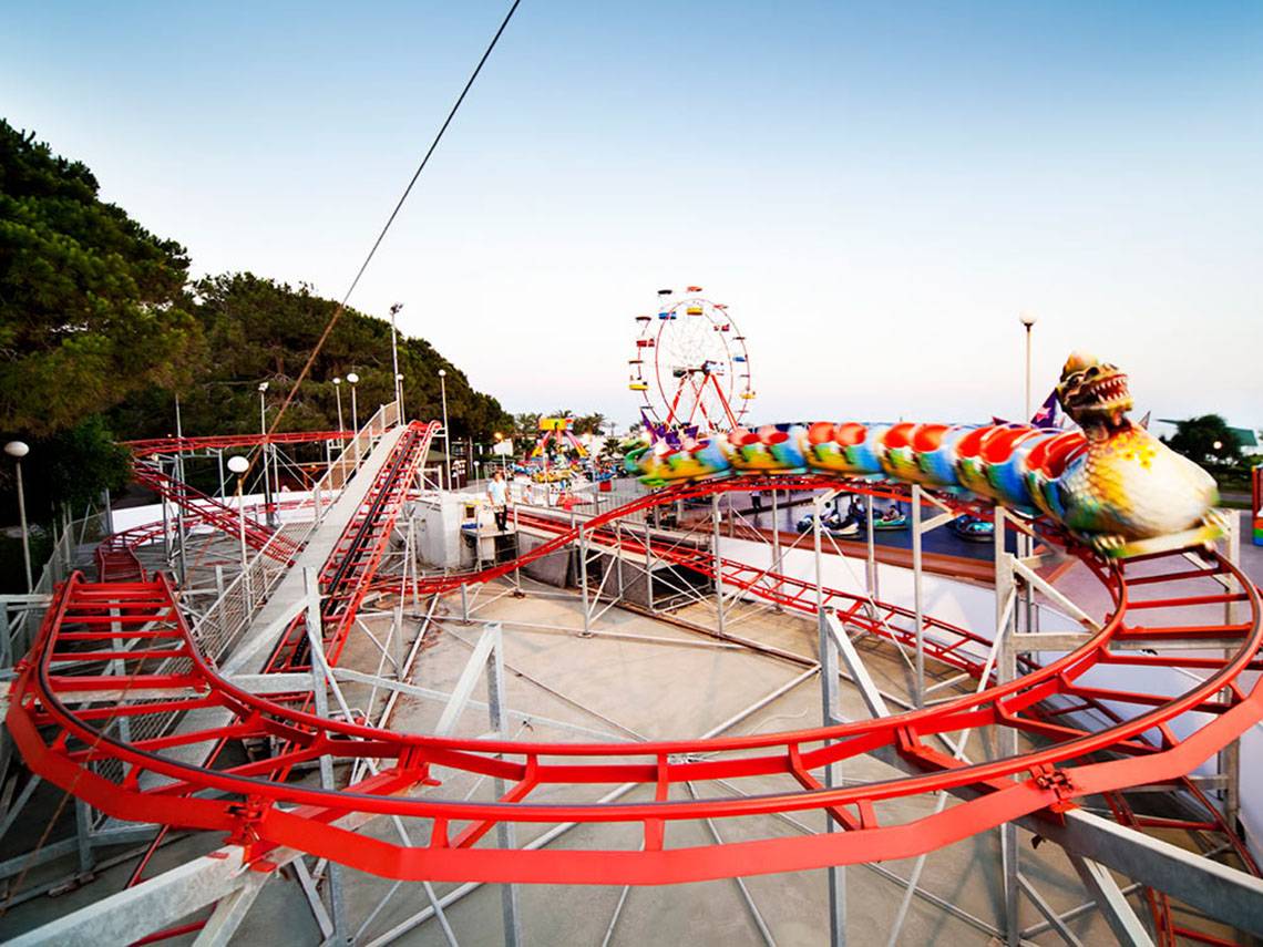 Achterbahn im Freizeitpark mit Sueno Hotels Beach Side im Hintergrund.