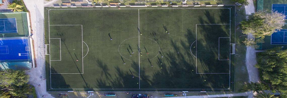 Luftaufnahme des Fußballplatzes im Meeru Island Resort & Spa mit Spielern und Trainingsaktivitäten