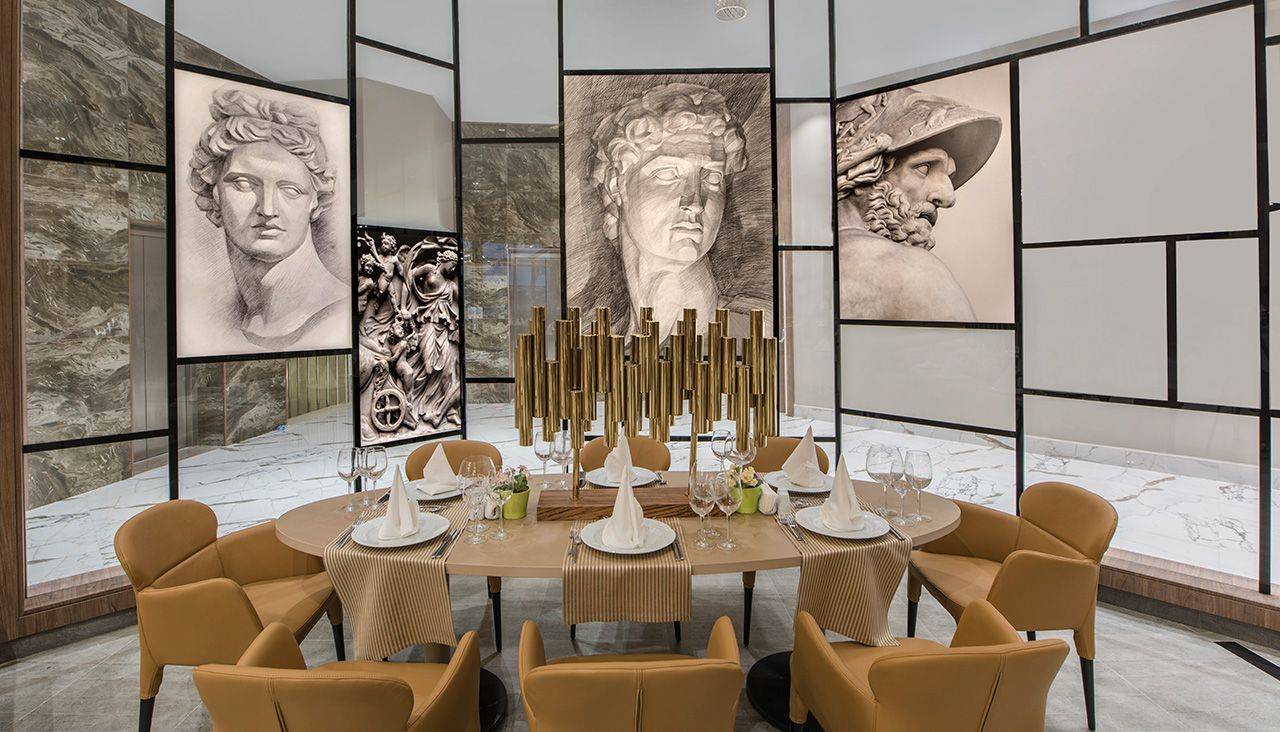 Elegantes Restaurant im Delphin BE Grand Resort mit stilvollen Stühlen und beeindruckenden Kunstwerken an der Wand.