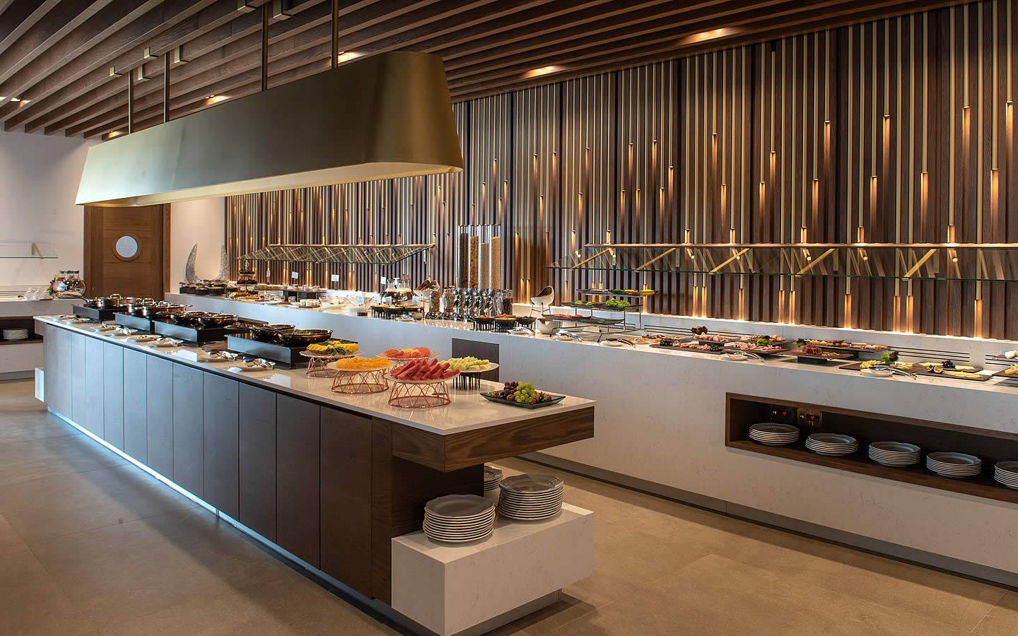 Buffettisch im Nana Princess Suites Hotel mit verschiedenen Speisen und goldenen Säulen.