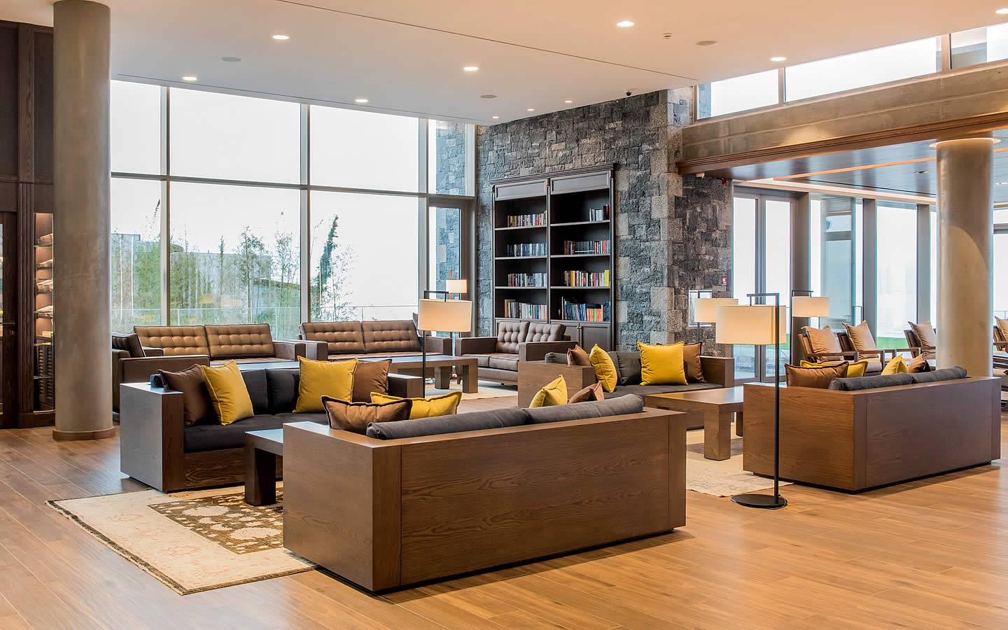 Innenansicht der Lounge des Nana Princess Suites, Villas & Spa mit Sofas, Teppichen und Bücherregalen.