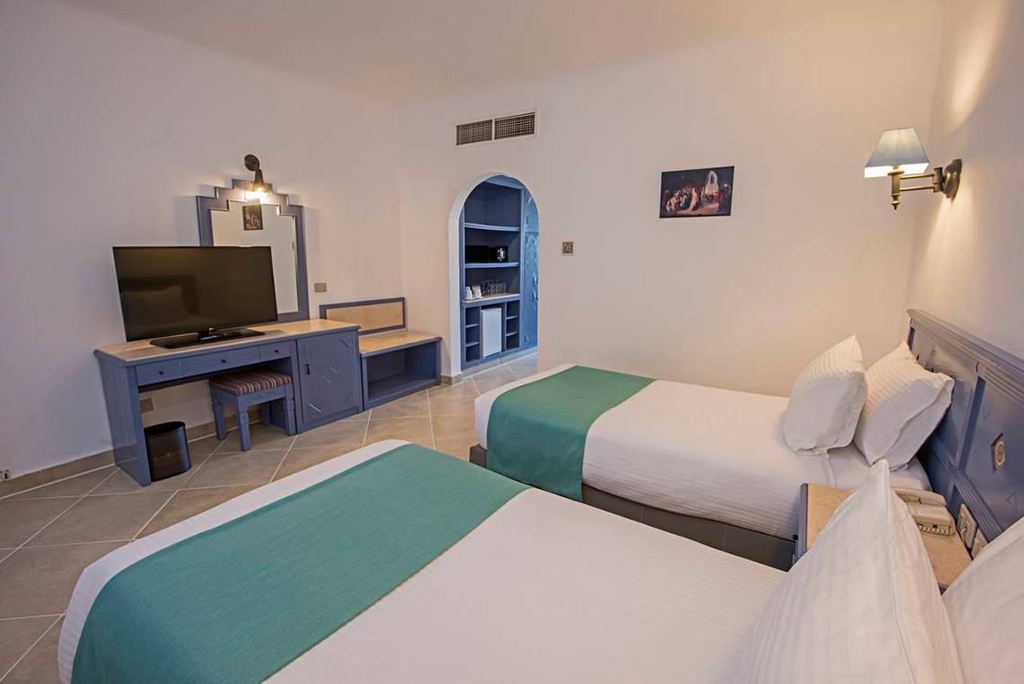 Zwei Betten in einem Hotelzimmer mit Fernseher und Schreibtisch.