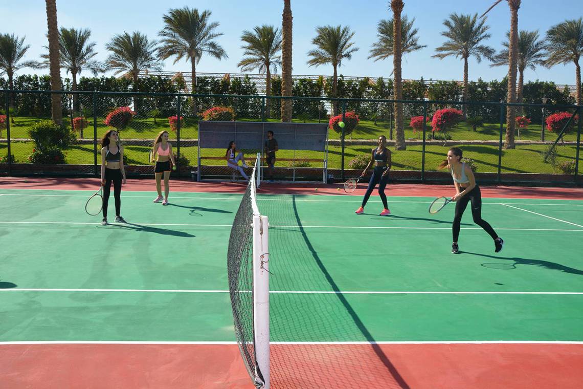 Tennisspielerinnen im Sunrise Royal Makadi Resort spielen auf einem Tennisplatz.