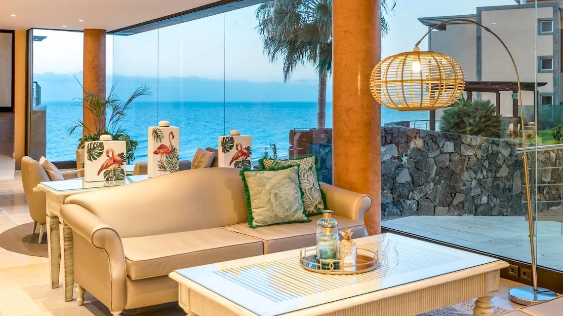 Wohnbereich im Iberostar Playa Gaviotas Park mit Blick auf das Meer und eine große Fensterfront.