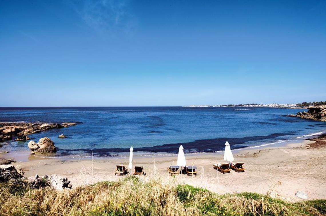 Strand mit Sonnenliegen unter Sonnenschirmen vor dem Amphora Hotel & Suites.