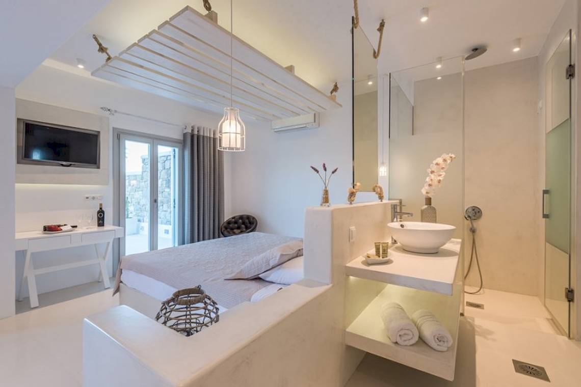 Suite im Sunrise Mykonos Hotel mit Bett, Fernseher und Dusche.
