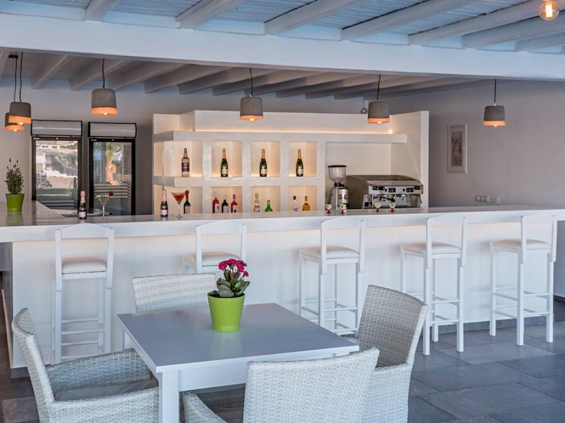 Barbereich im Sunrise Mykonos Hotel mit weißer Theke und Sitzgelegenheiten.