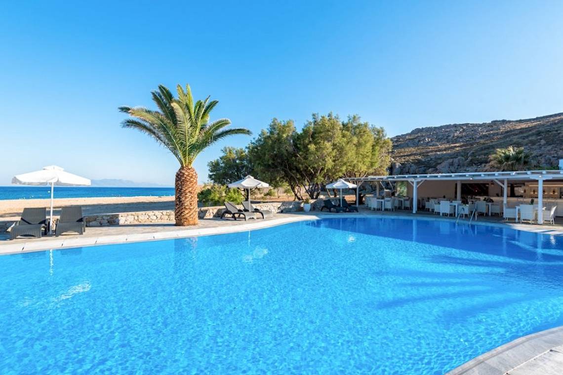 Außenpool des Sunrise Mykonos Hotels mit Sonnenliegen und Sonnenschirmen am Strand