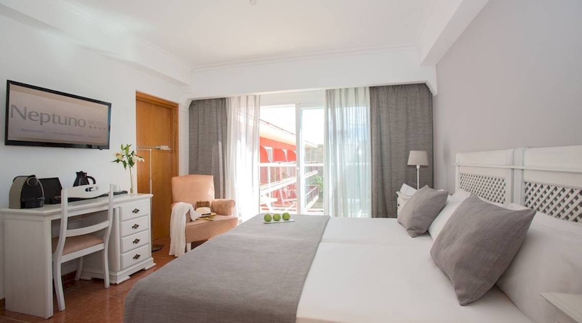 Zimmer im Universal Hotel Neptuno mit Bett, Schreibtisch, Fernseher und Balkon