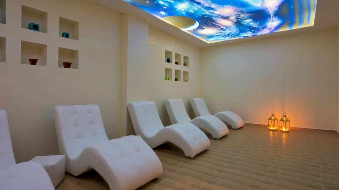 Ein Entspannungsraum im Iberostar Founty Beach Hotel mit weißen Liegen und Sternenhimmelprojektion.