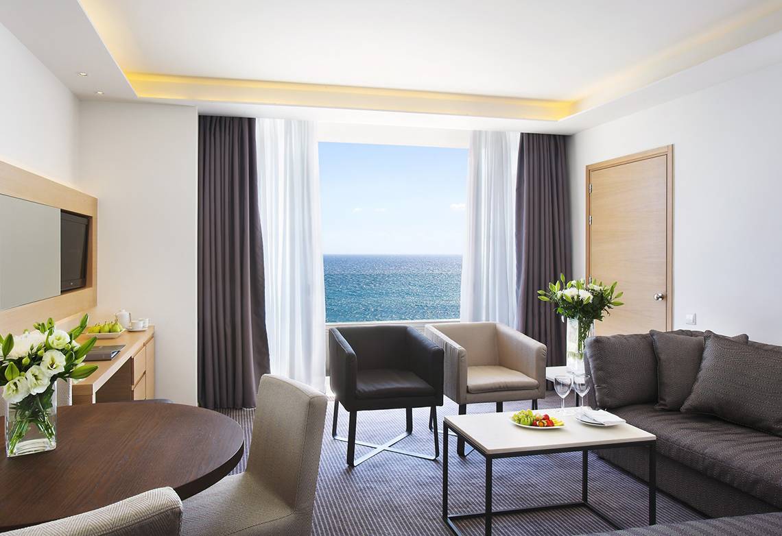 Innenansicht der Suite im Royal Apollonia Beach Hotel mit Blick auf das Meer.