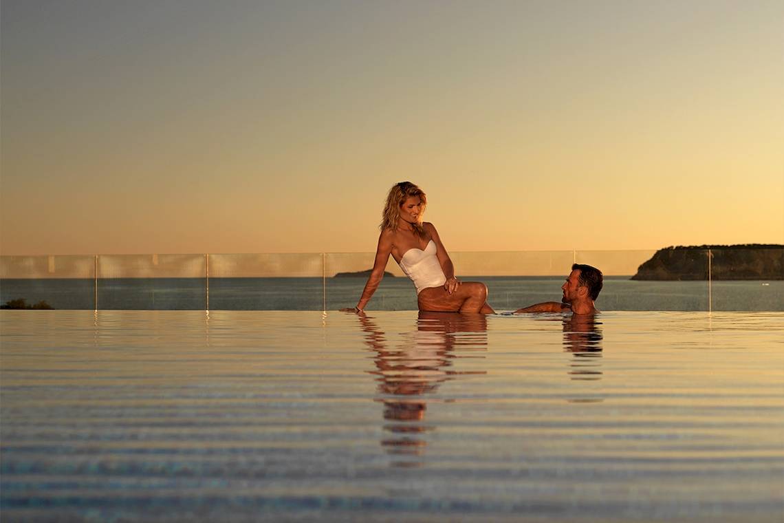Ein Paar entspannt sich im Pool des Dubrovnik President Valamar Collection Hotels bei Sonnenuntergang.