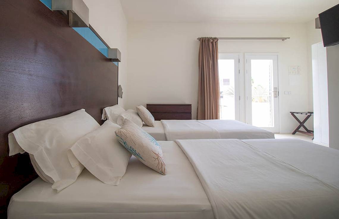 Doppelzimmer im Hotel Dunas De Sal mit zwei Betten und weißen Laken.
