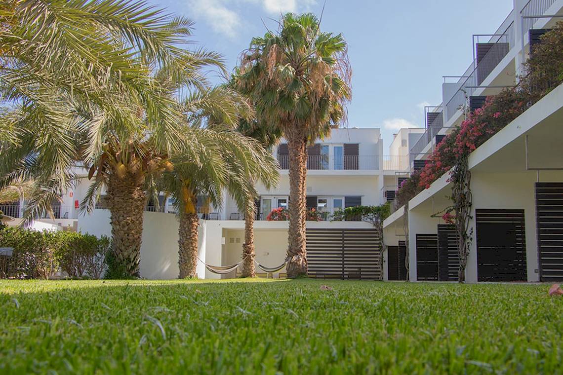 Vorgarten des Dunas De Sal Hotels mit Palmen und Blumen